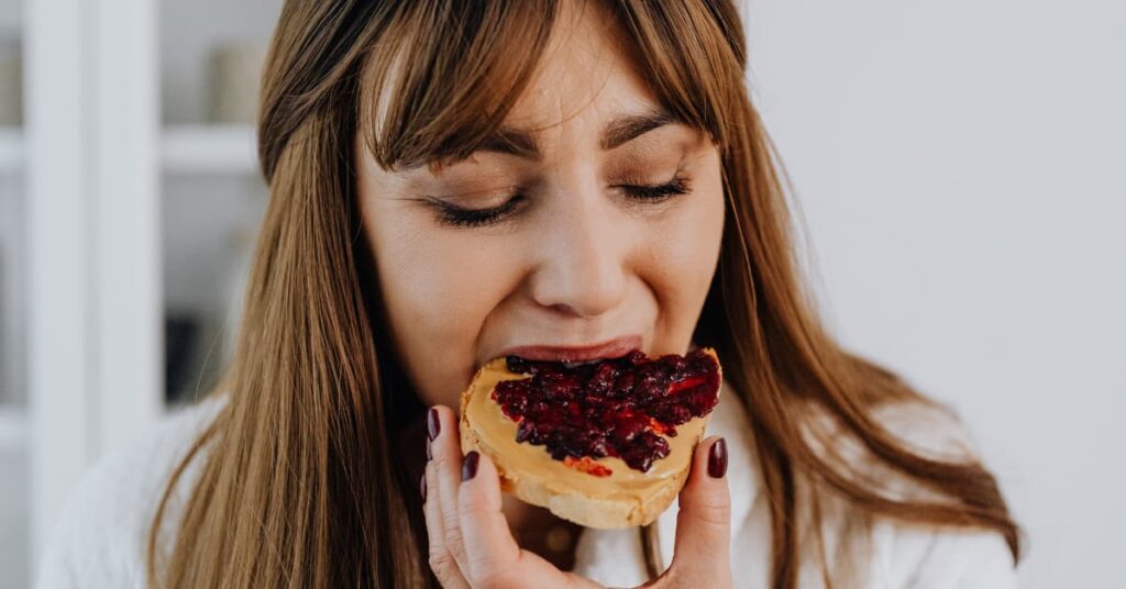 Mulher comendo doce por compulsão alimentar.