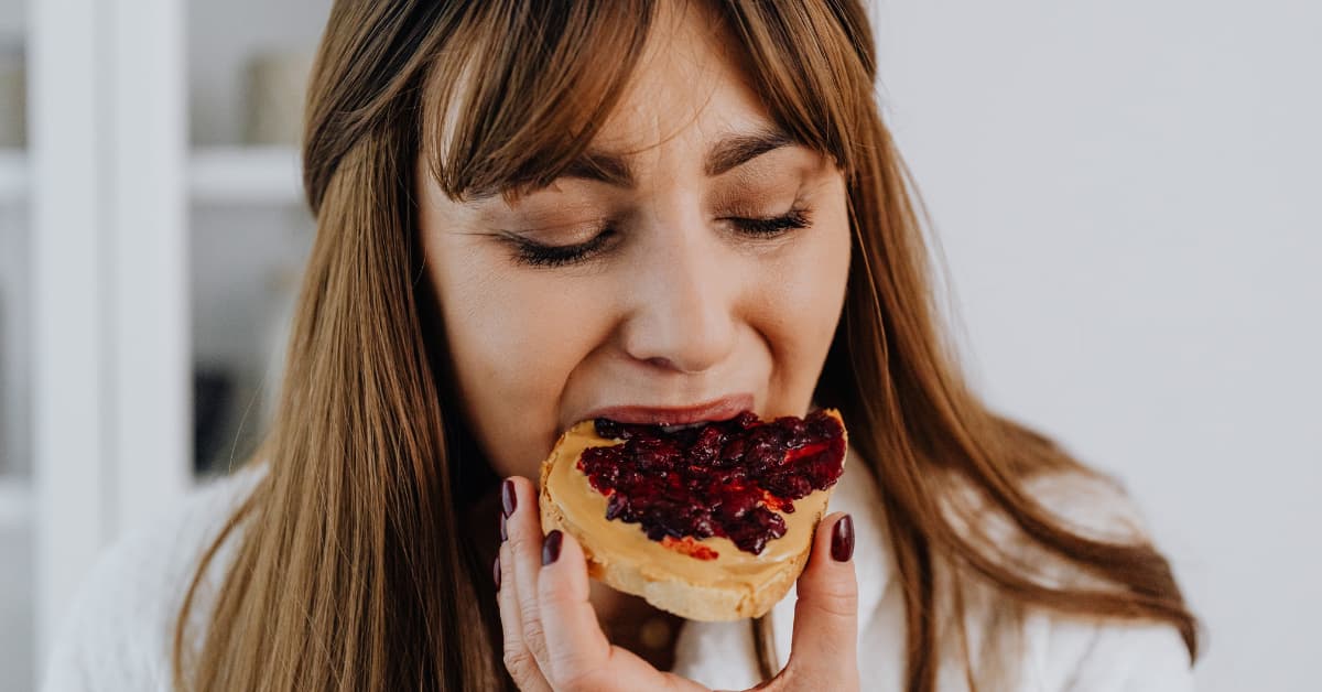 Mulher comendo doce por compulsão alimentar.