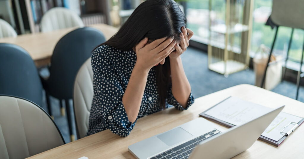 Mulher cansada no trabalho e com o peso travado sem saber o que comer
