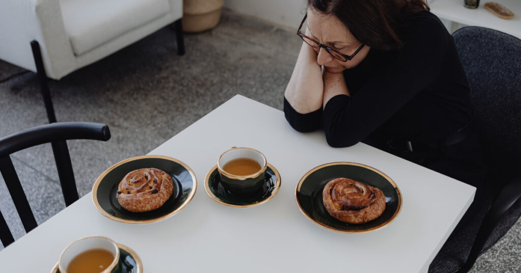 Mulher frustada no trabalho, com fome e sem saber o que comer.