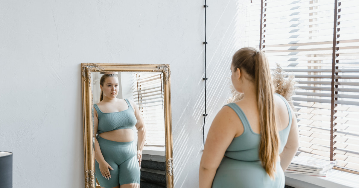 Mulher de trinta anos olhando para a balança refletindo sobre o metabolismo lento e a dificuldade de emagrecer.