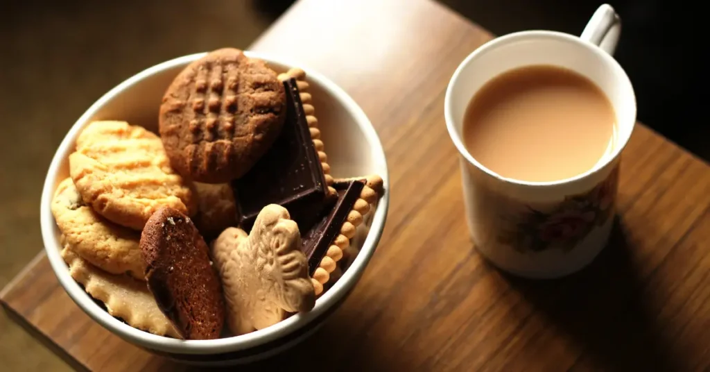 Café preto com biscoito mostrando um café da manhã inadequado para o emagrecimento.