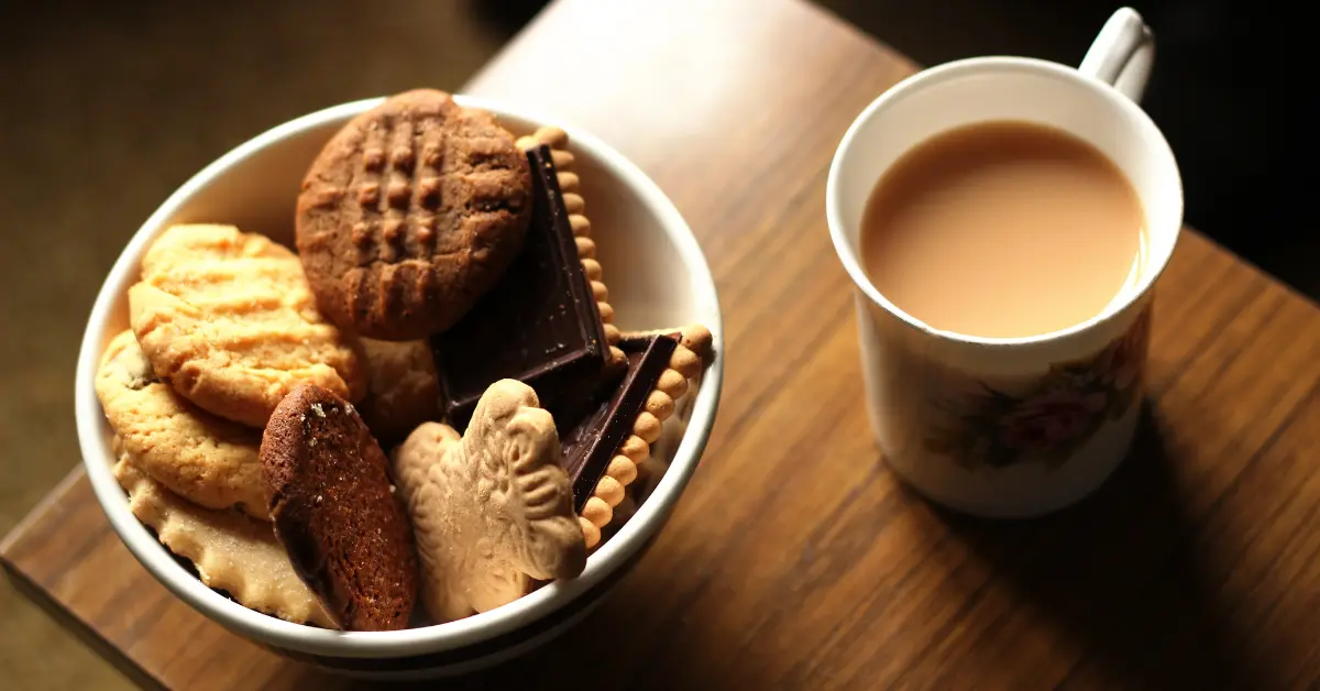 Café preto com biscoito mostrando um café da manhã inadequado para o emagrecimento.