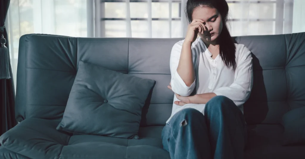 Mulher sentindo cansaço mental e fome incontrolável à noite após o trabalho.