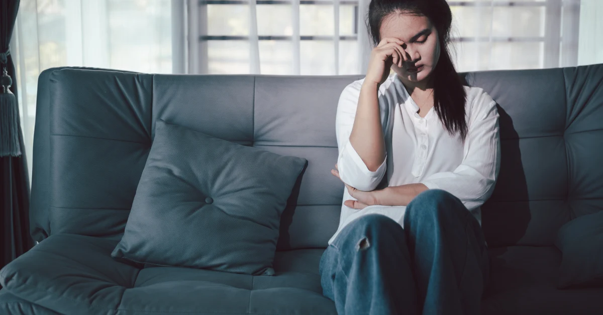 Mulher sentindo cansaço mental e fome incontrolável à noite após o trabalho.