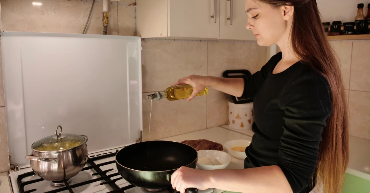 Mulher usando azeite sem mensurar, dificultando o processo de emagrecimento.