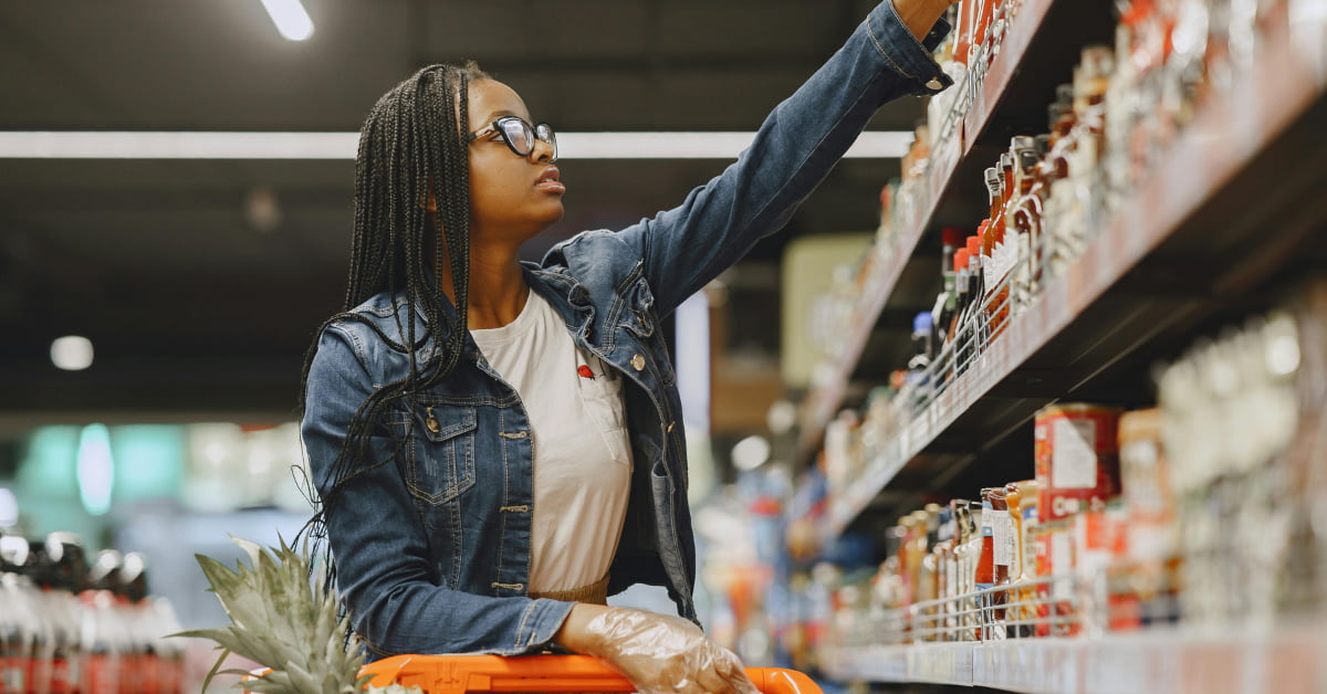 Mulher analisando barra de cereal e produtos fit que parecem saudáveis mas não são.