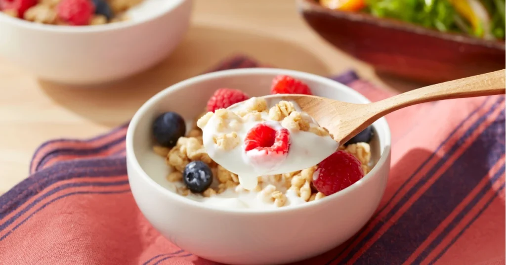 Como consumir mais proteína no dia a dia: lanche prático com iogurte, frutas e sementes.